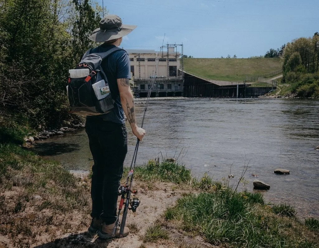 Fisherman at a river wearing a fishing backpack: Review of the best fishing backpack