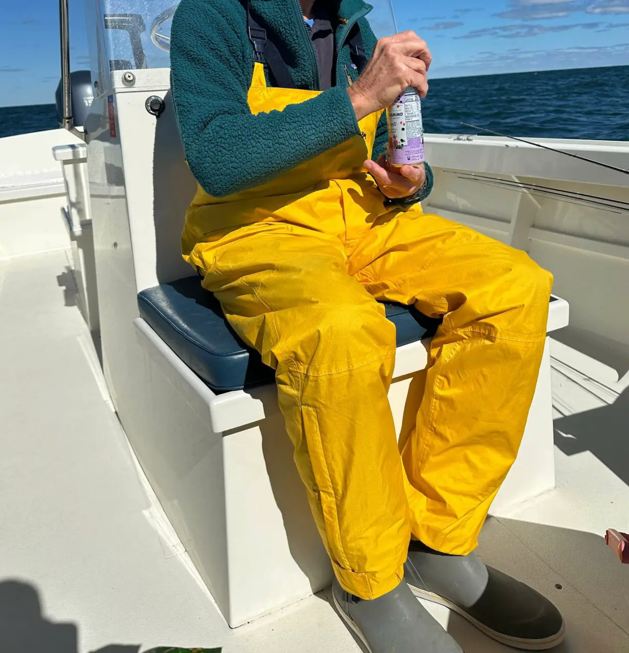 Fisherman wearing a fishing bib on a boat - review of the best fishing bibs